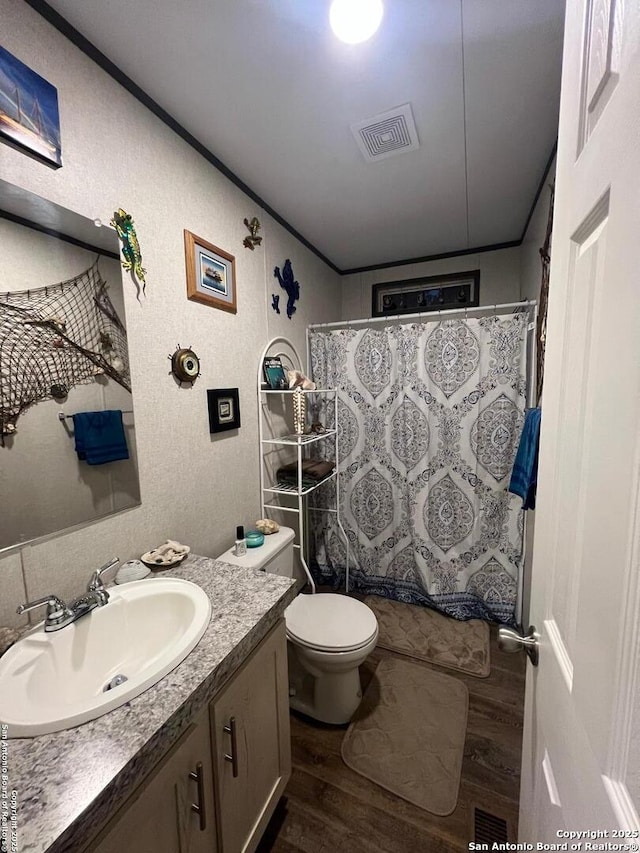 bathroom with hardwood / wood-style flooring, ornamental molding, toilet, vanity, and a shower with shower curtain