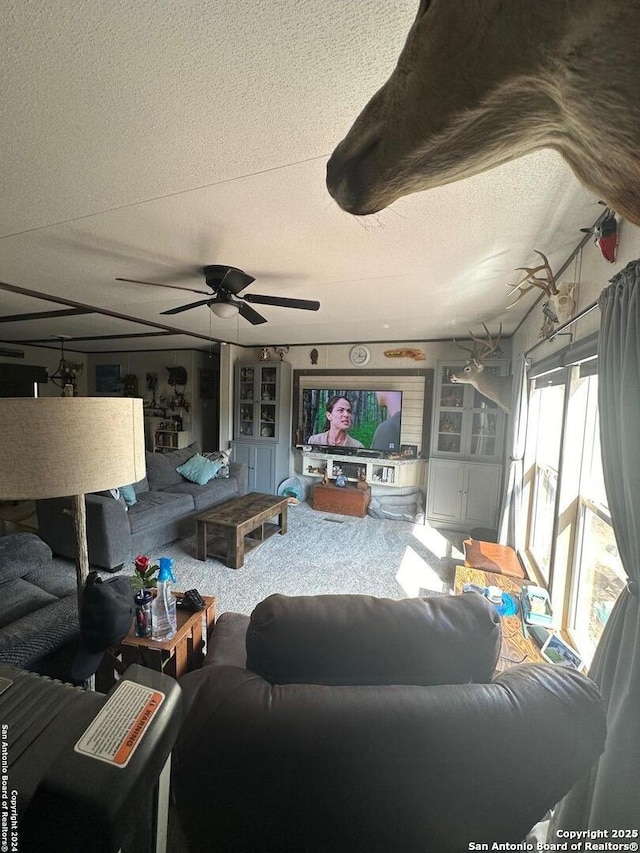 carpeted living room featuring ceiling fan and a textured ceiling