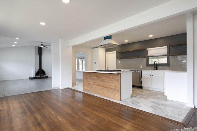 kitchen with white cabinetry, ventilation hood, a center island, stainless steel appliances, and decorative backsplash