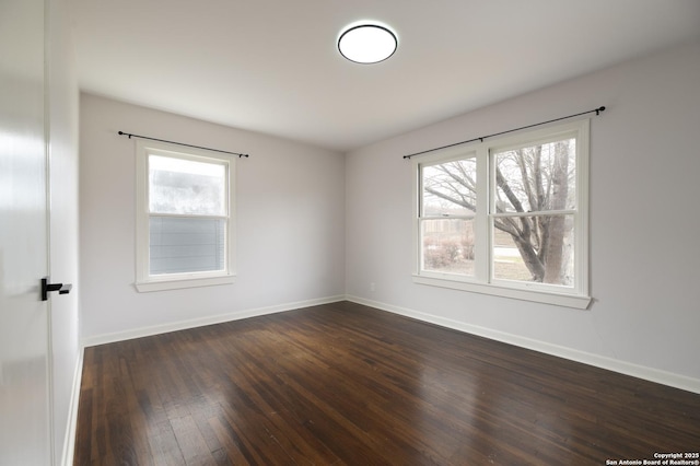 unfurnished room with a healthy amount of sunlight and dark hardwood / wood-style flooring