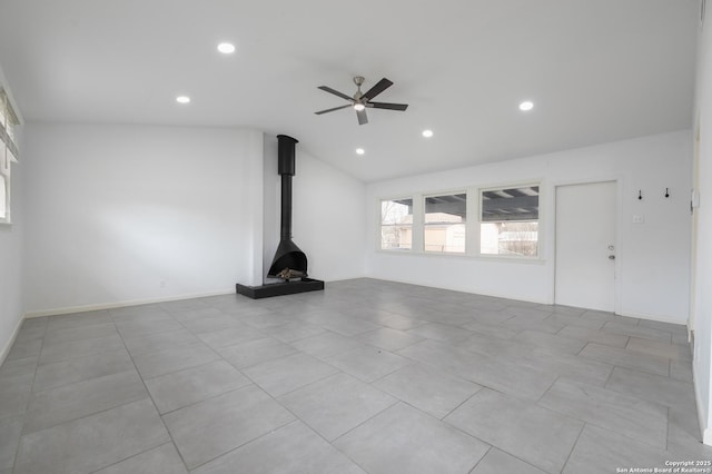 unfurnished living room featuring ceiling fan, lofted ceiling, and a wood stove