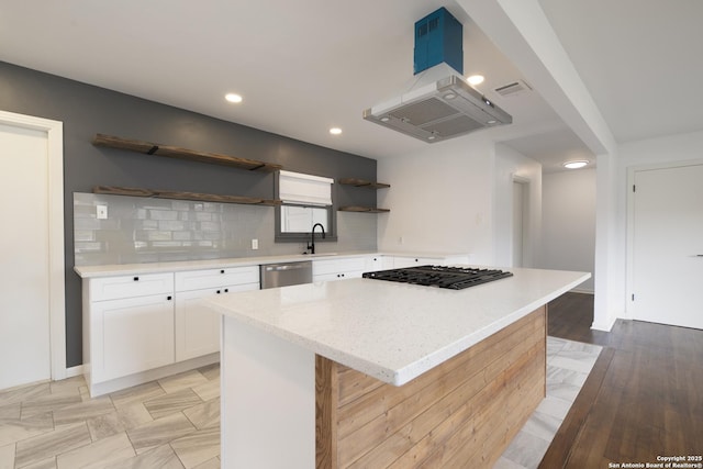 kitchen featuring sink, white cabinetry, tasteful backsplash, a center island, and stainless steel appliances