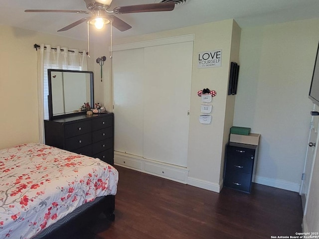 bedroom with dark hardwood / wood-style flooring, a closet, and ceiling fan