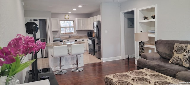 living room featuring sink, light wood-type flooring, and built in shelves