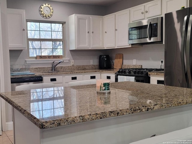 kitchen featuring white cabinetry, sink, light stone counters, and black appliances