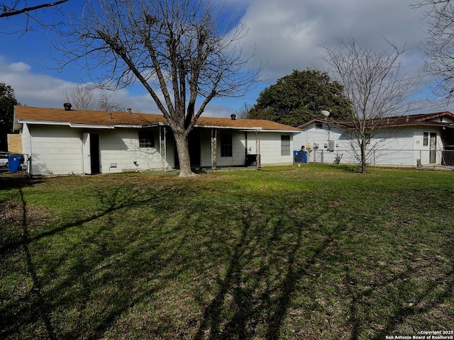 rear view of house featuring a lawn