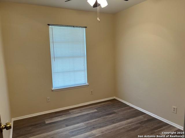 unfurnished room with dark wood-type flooring and ceiling fan