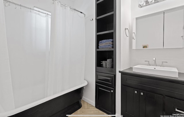 bathroom featuring parquet floors, shower / tub combo with curtain, vanity, and tasteful backsplash