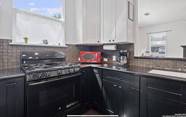 kitchen with black range with gas cooktop, decorative backsplash, and white cabinets