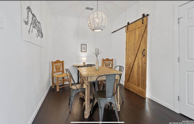 dining space featuring dark wood-type flooring and a barn door