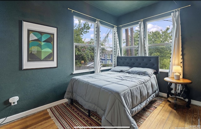 bedroom featuring multiple windows and hardwood / wood-style floors