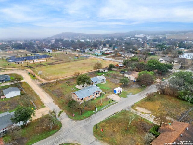 1102 Berlin St, Castroville, TX 78009 - aerial view of property and surrounding area with a mountainous background and nearby suburban area