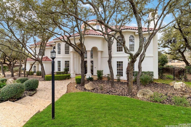 mediterranean / spanish home featuring a front yard