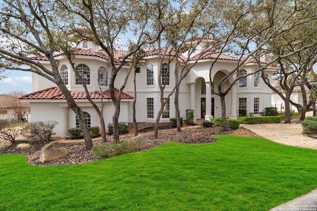 mediterranean / spanish house featuring a front lawn