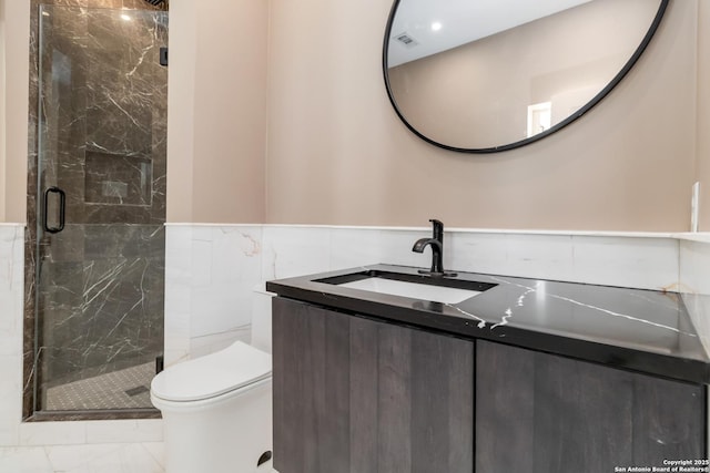 bathroom featuring tile walls, vanity, a shower with shower door, and toilet