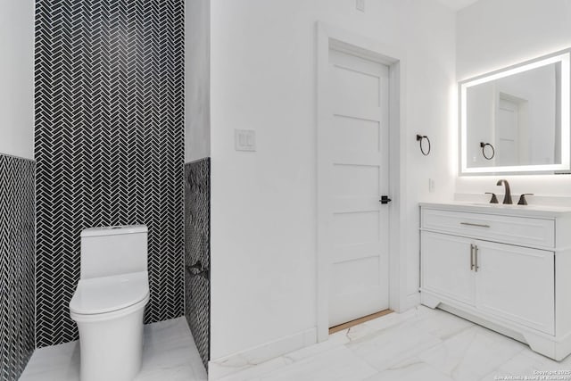 bathroom with vanity, tile walls, and toilet