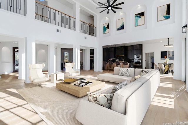 living room with light hardwood / wood-style floors and ceiling fan