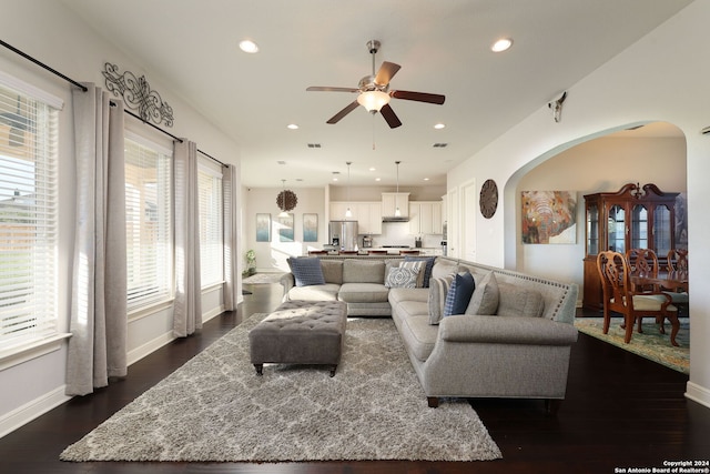 living room featuring dark wood-type flooring and ceiling fan