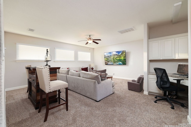 living room featuring light colored carpet and ceiling fan