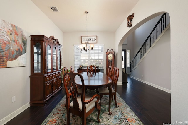 dining space featuring dark wood-type flooring and a chandelier