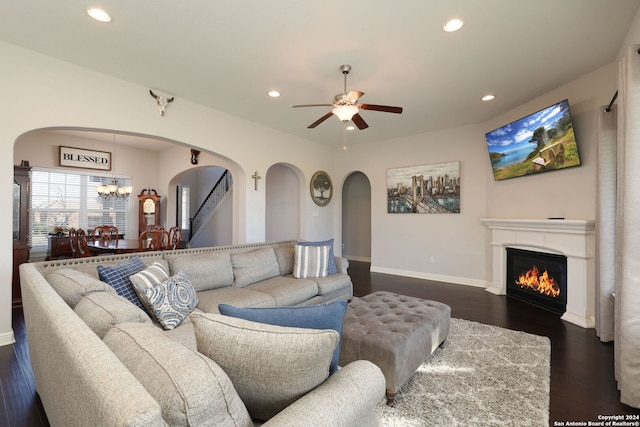 living room featuring dark hardwood / wood-style floors and ceiling fan with notable chandelier