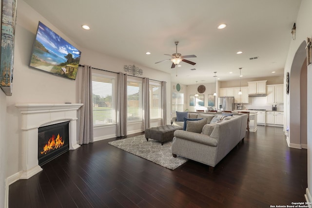 living room with dark hardwood / wood-style floors and ceiling fan