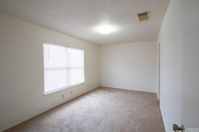 carpeted spare room featuring a textured ceiling