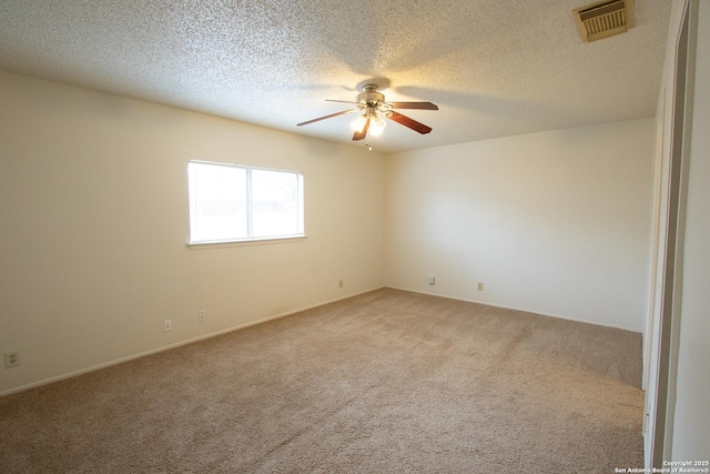 empty room with light colored carpet, a textured ceiling, and ceiling fan