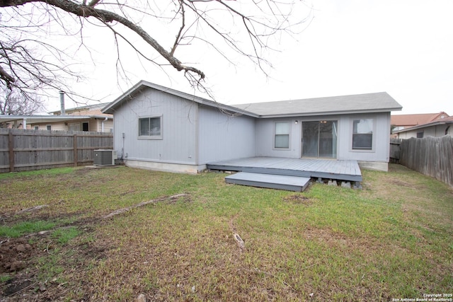 back of property with a wooden deck, central AC unit, and a lawn