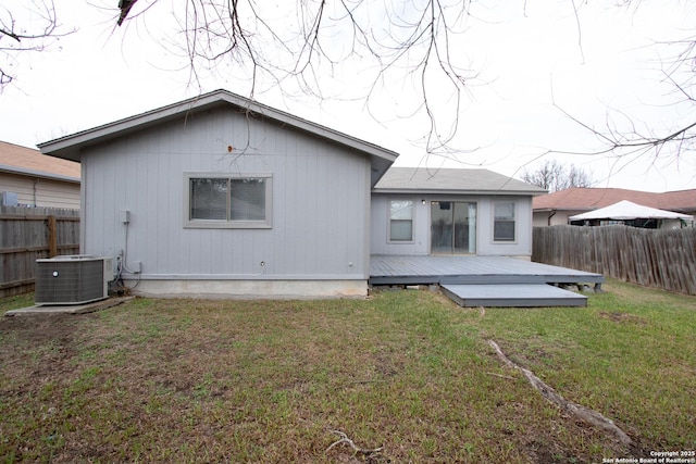 back of property with a wooden deck, a lawn, and central air condition unit