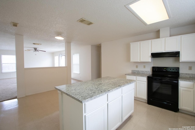 kitchen with white cabinetry, a center island, black / electric stove, ceiling fan, and light stone countertops