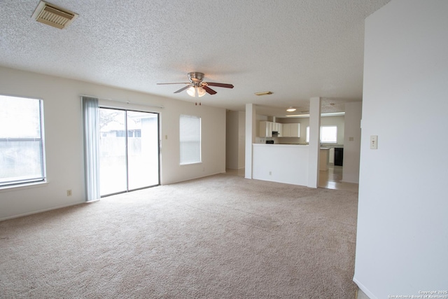 unfurnished living room with carpet floors, a textured ceiling, and ceiling fan