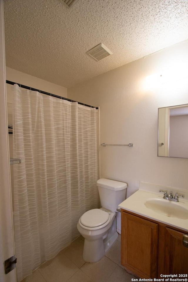 bathroom with walk in shower, toilet, a textured ceiling, vanity, and tile patterned flooring