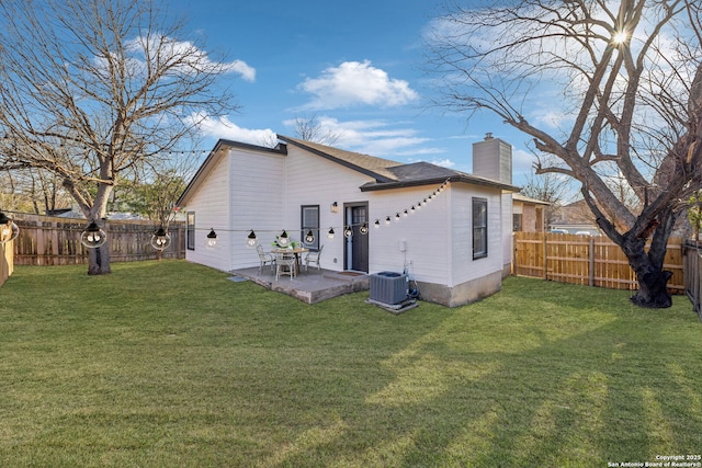 back of house featuring cooling unit, a patio area, and a lawn