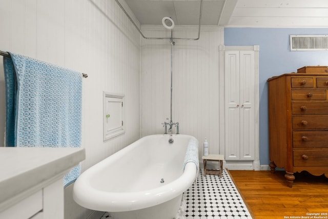 bathroom with a tub to relax in and hardwood / wood-style floors