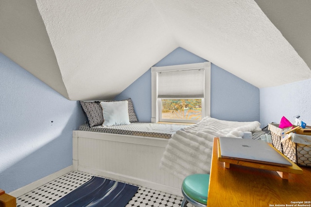 bedroom with lofted ceiling and a textured ceiling