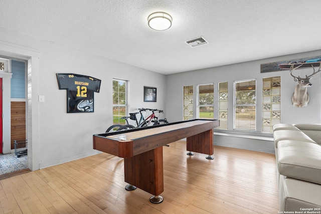 rec room featuring a textured ceiling and light hardwood / wood-style floors