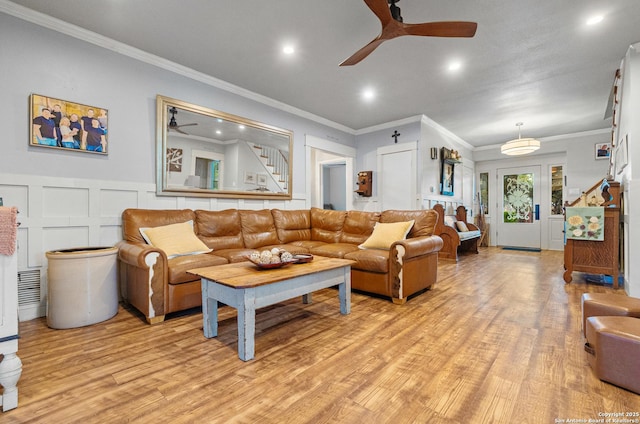 living room with crown molding, ceiling fan, and light hardwood / wood-style floors