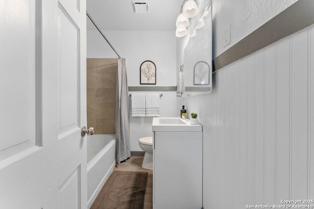 full bathroom with shower / tub combo with curtain, vanity, and toilet