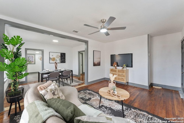 living room with ceiling fan and dark hardwood / wood-style flooring