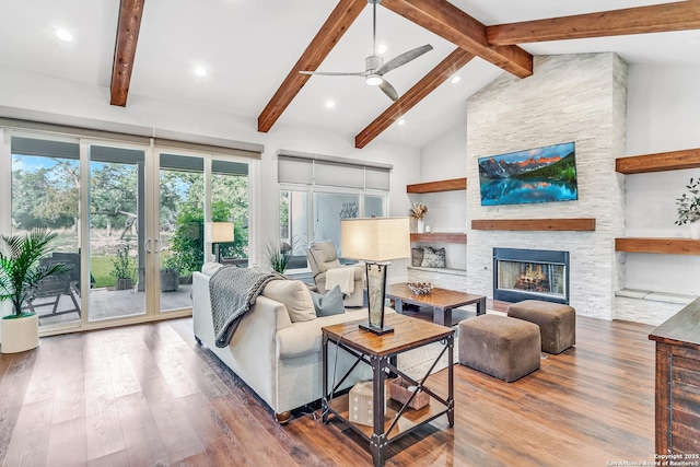 living room featuring hardwood / wood-style flooring, high vaulted ceiling, a fireplace, and beamed ceiling