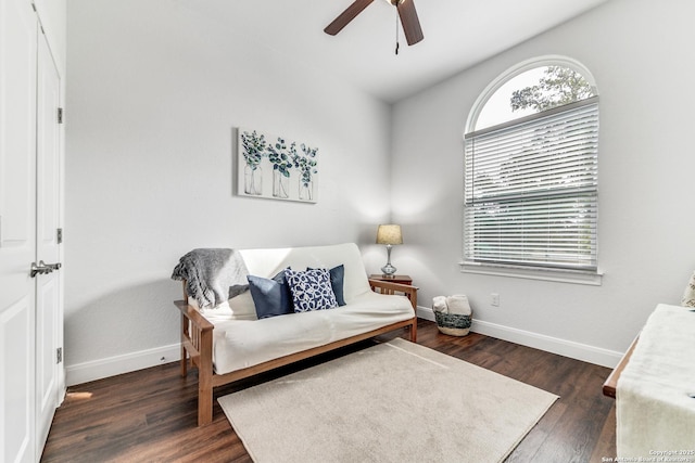 living area with dark wood-type flooring and ceiling fan