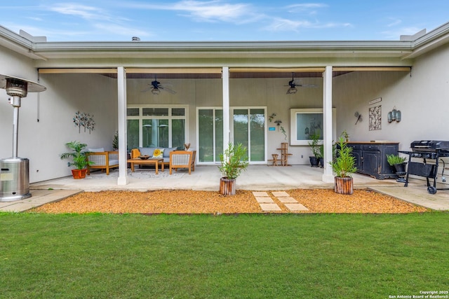 rear view of house featuring a jacuzzi, a patio area, a lawn, outdoor lounge area, and ceiling fan