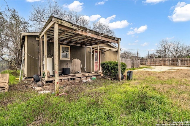 view of outbuilding featuring fence and an outdoor structure