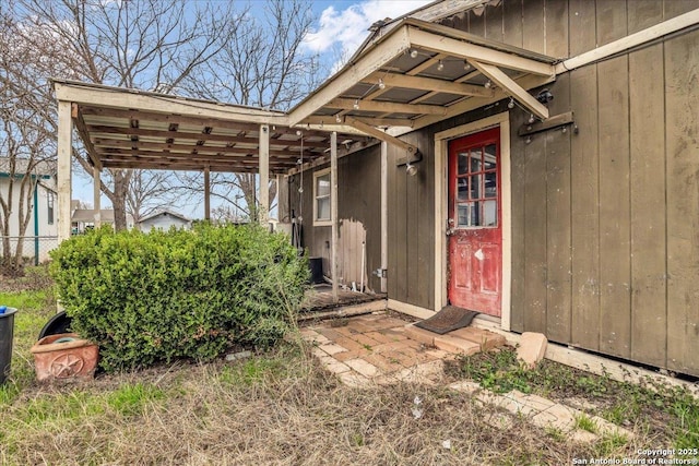 property entrance featuring fence and a carport