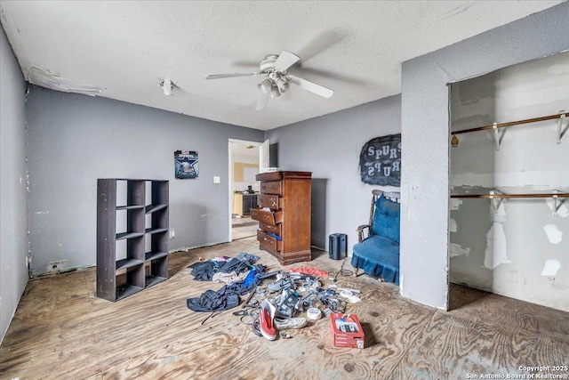 bedroom with ceiling fan and a textured ceiling