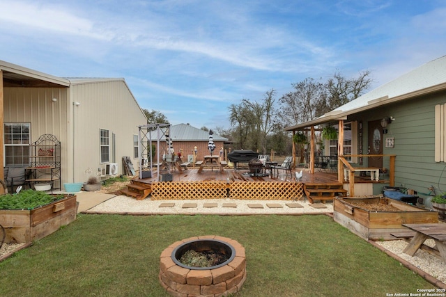 view of yard with cooling unit, an outdoor fire pit, and a deck