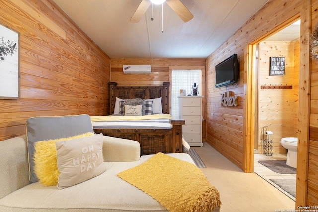 bedroom featuring ceiling fan, wood walls, ensuite bath, and an AC wall unit