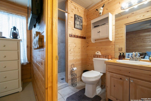 bathroom with tile patterned flooring, vanity, wooden walls, and toilet