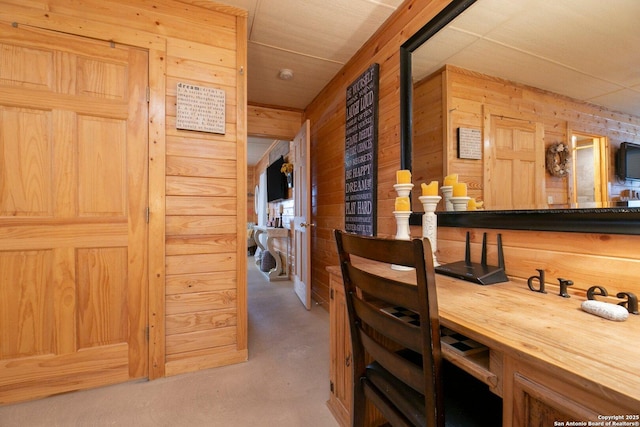 hallway featuring concrete flooring and wood walls